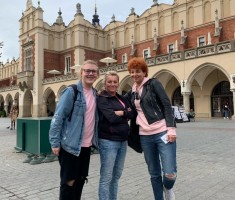 Powiększ zdjęcie Opiekunowie z uczniem na tle Sukiennic