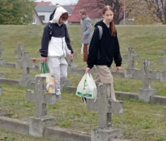 Powiększ zdjęcie Uczniowie wśród grobów poległych żołnierzy