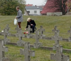 Powiększ zdjęcie Uczniowie zapalają znicze na grobach żołnierzy