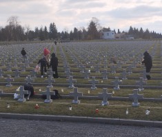 Powiększ zdjęcie Młodzież zapalająca znicze na grobach żołnierzy