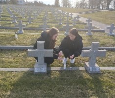 Powiększ zdjęcie Młodzież zapalająca znicze na grobach żołnierzy