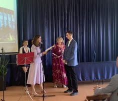 Powiększ zdjęcie Pani Dyrektor wręczająca uczniowi nagrodę