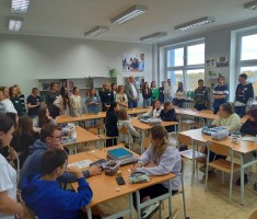 Powiększ zdjęcie Zdjęcie przedstawia uczestników warsztatów podczas zwiedzania pracowni szkolnych