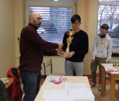 Powiększ zdjęcie Kapitan zespołu - Alan Chochel odbiera pamiątkowy puchar za I miejsce w Mistrzostwach Powiatu w Szachach Drużynowych
