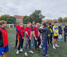 Powiększ zdjęcie Opiekun sztafety chłopców zawiesza na szyjach chłopców wywalczone medale