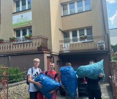 Powiększ zdjęcie Uczniowie z nakrętkami przed budynkiem Fundacji